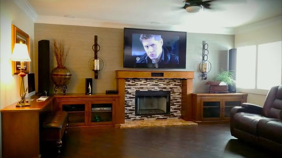 Warm family room with stacked-stone fireplace and leather sectional