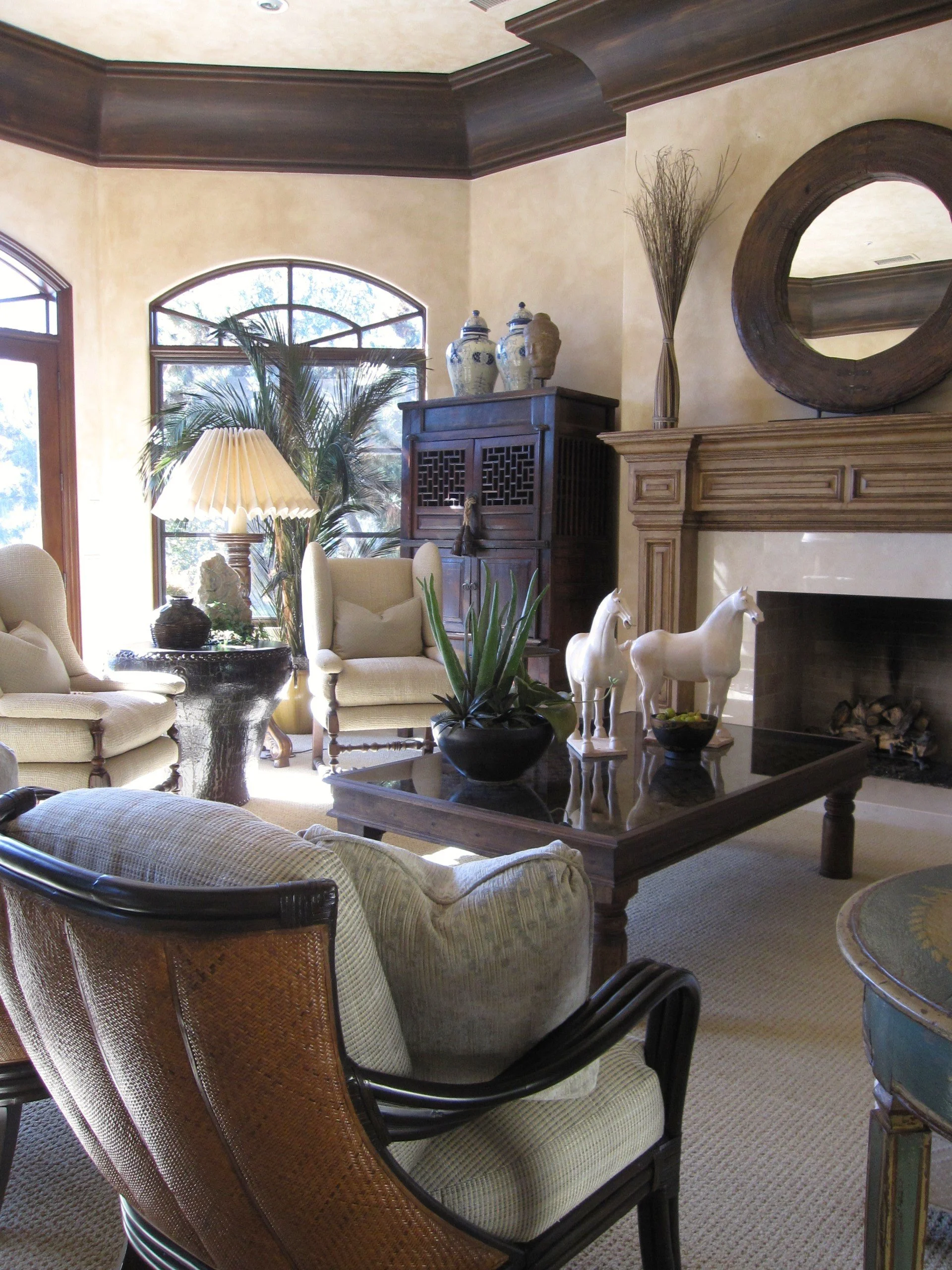 Mediterranean living room with carved stone fireplace, interior design by Matthew Alexander Creations