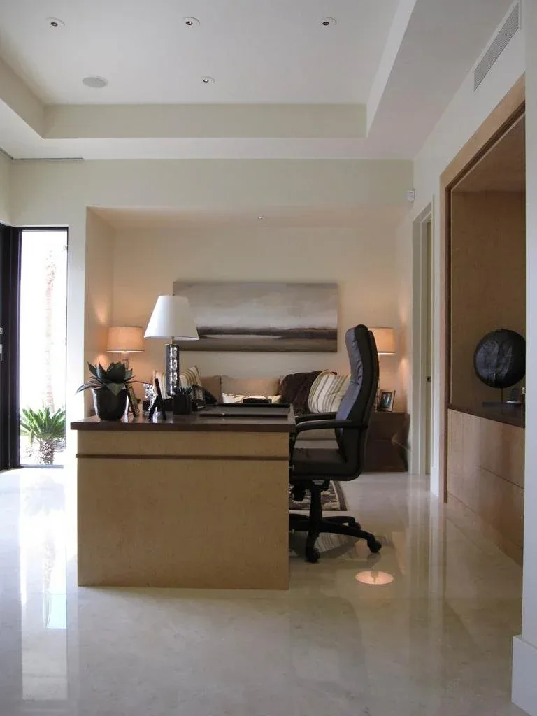 Home office with a floating built-in desk, marble floor and abundant natural light.