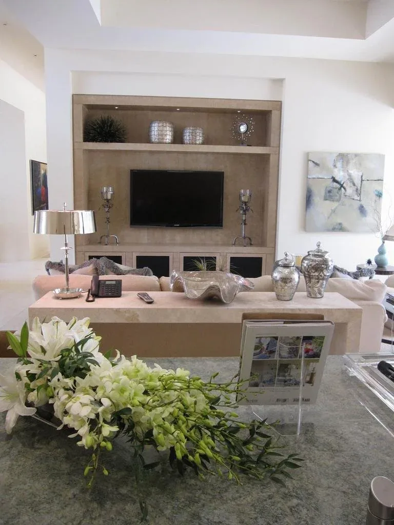 Neutral living room with a built-in media niche, coffered detailing and relaxed seating.