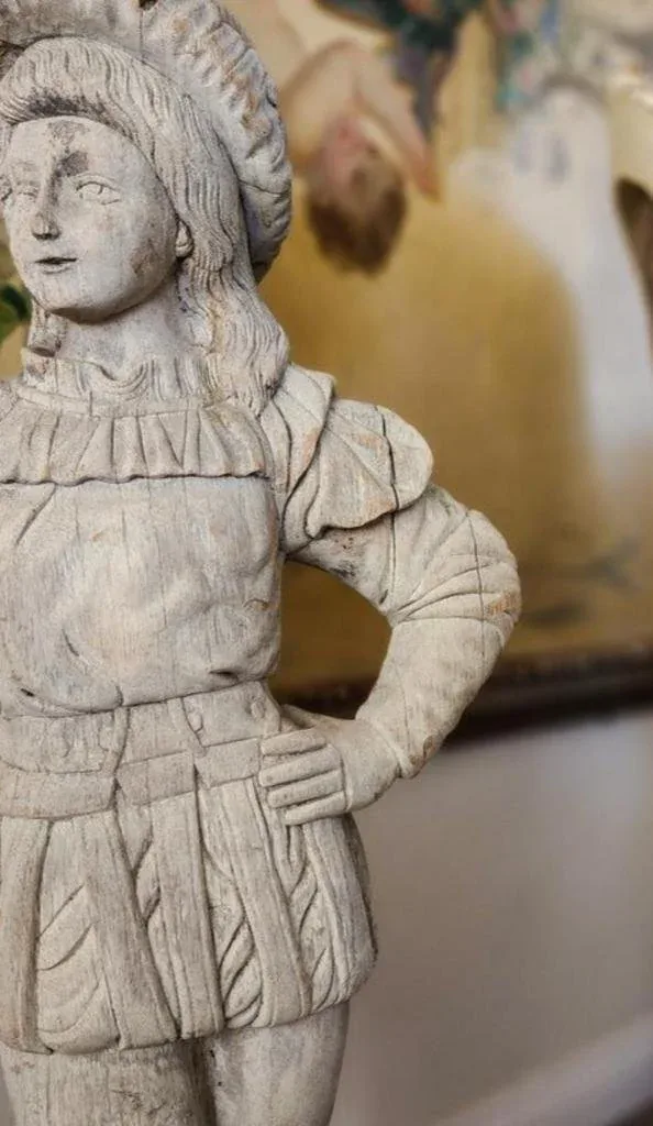 Close-up of a carved wooden figural sculpture used as a styling accent.