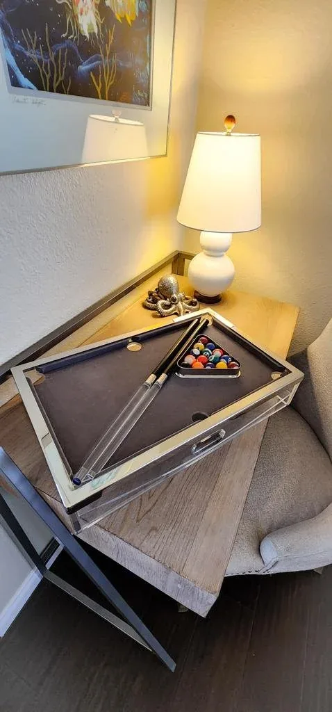 Bedside vignette with a ceramic lamp and a set of geometric serving trays.