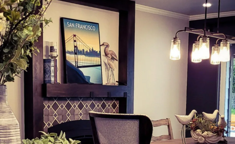 Eclectic dining area with layered framed art, a cluster of glass pendants and mixed seating.