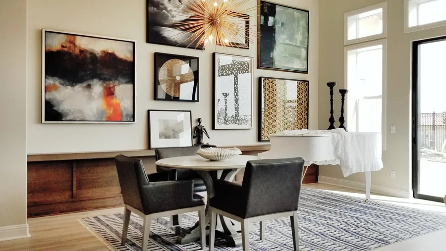 Sunlit dining area with a gold sunburst mirror, framed gallery wall and modern dining set.