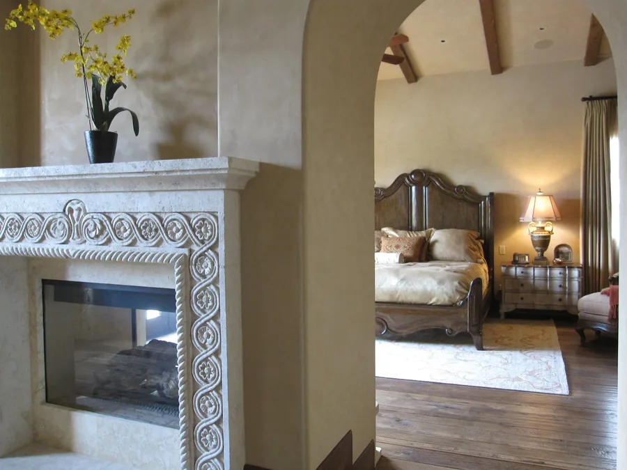 Primary bedroom suite with an ornate silver fireplace surround and a traditional bed.