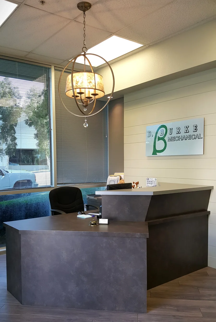 Commercial reception with a polished concrete desk and a backlit company sign.